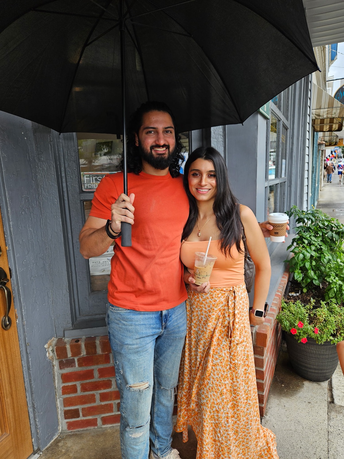Jennifer and Samir under an umbrella in the rain
